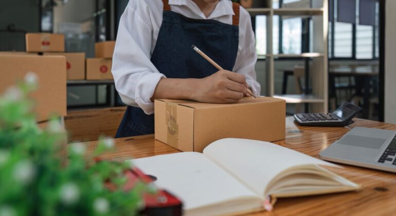 A business owner preparing a package for delivery, representing Ink Arrow Marketing Co. and its expertise in blending digital marketing and traditional marketing strategies.