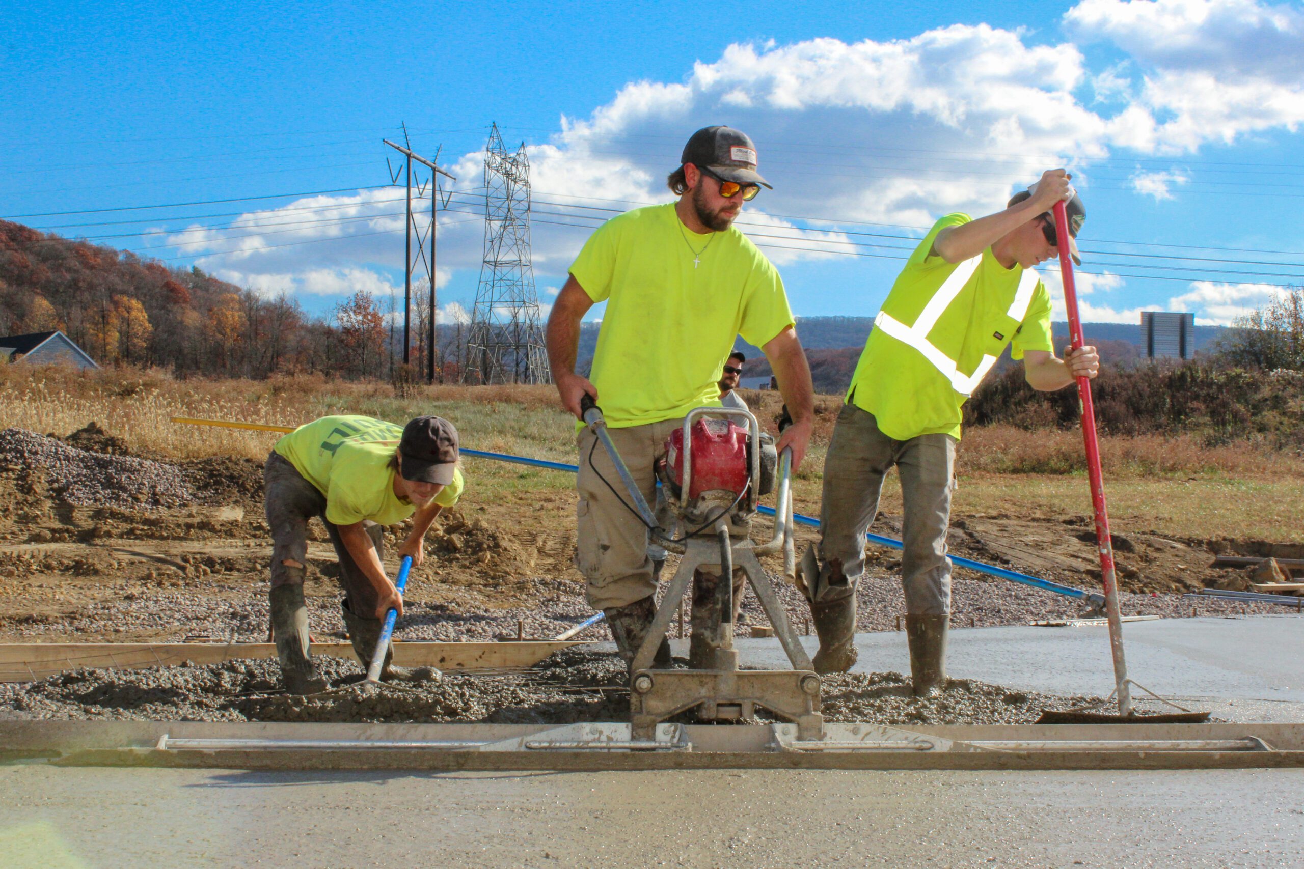 Concrete workers finishing a freshly poured driveway with precision and craftsmanship