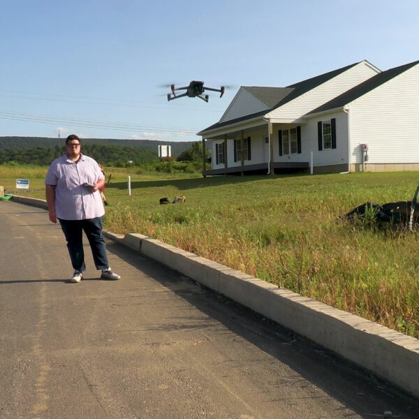 Drone technician prepping drone for aerial photography and video capture