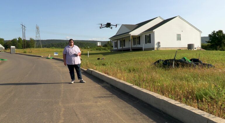 Drone technician prepping drone for aerial photography and video capture