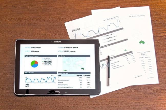 Tablet and papers showing charts and statistics of website traffic by Ink & Arrow highlighting local search visibility for businesses.